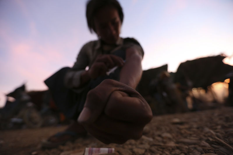 © Reuters. A miner injects heroin at a mine dump at a Hpakant jade mine in Kachin state