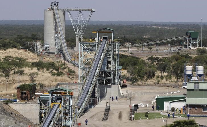 © Reuters. Employees walk under a concentrator at Ngezi platinum processing plant near Harare