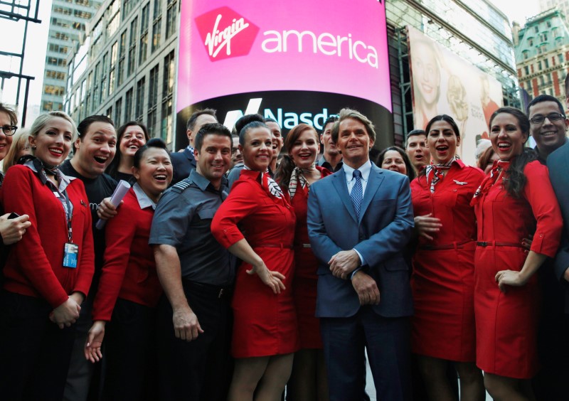 © Reuters. Virgin America Inc. President and Chief Executive Officer David Cush poses for photographs with Virgin America flight crews as Virgin America Inc. celebrated its initial public offering at the NASDAQ Market Site in New York