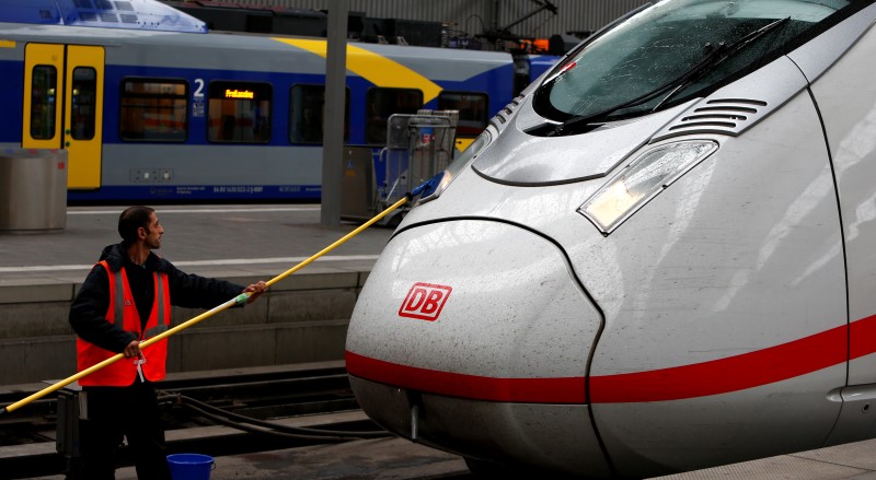 © Reuters. Employee cleans dirty front of ICE train of Deutsche Bahn at main train station in Munich