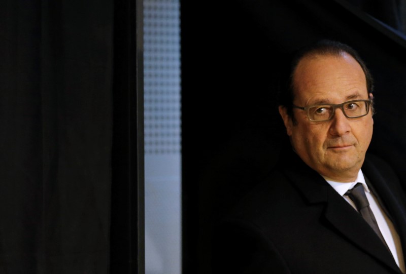 © Reuters. French President Francois Hollande leaves the voting booth to cast his ballot for the second-round in the regional elections in Tulle