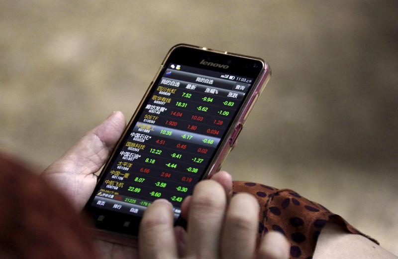© Reuters. File photo of an investor checking stock information on her mobile phone in Beijing