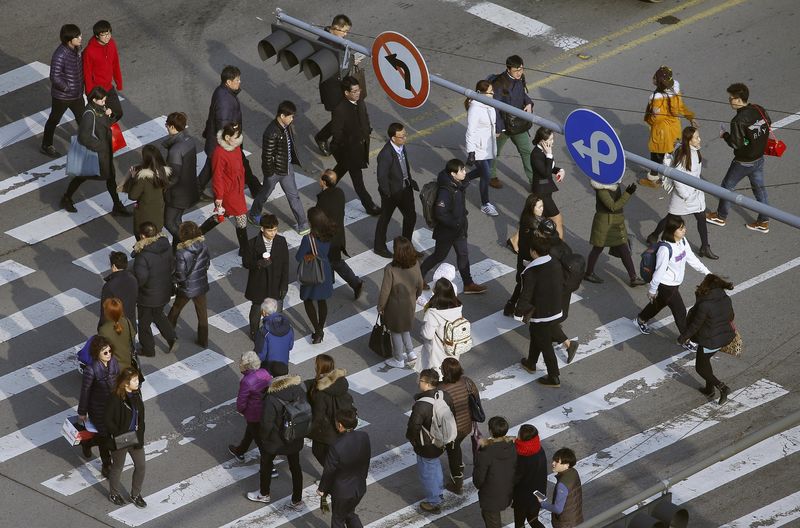 © Reuters. People cross a zebra crossing in a business district in central Seoul