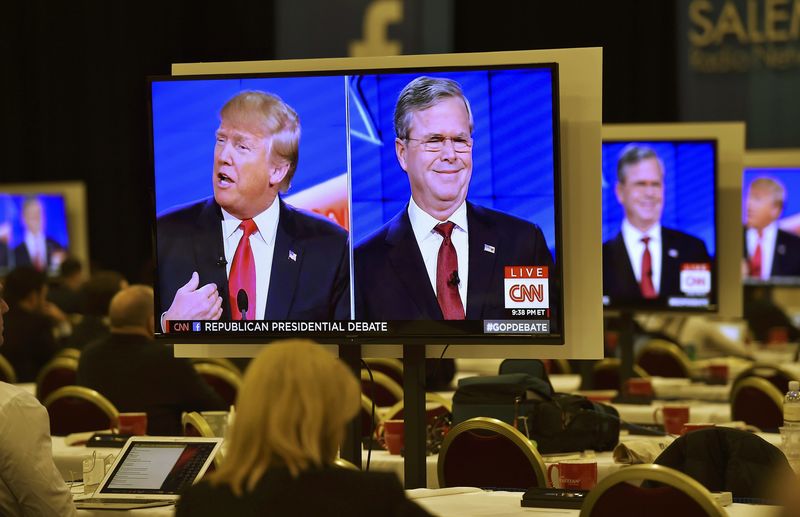 © Reuters. Republican U.S. presidential candidates businessman Donald Trump and  former Governor Jeb Bush are seen debating on video monitors in the debate press room during the Republican presidential debate in Las Vegas