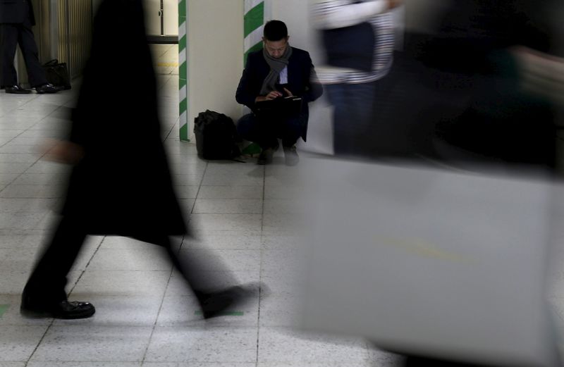 © Reuters. A man uses his laptop at a train station in a business district in Tokyo, Japan