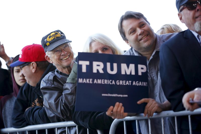 © Reuters. People listen to Republican presidential candidate Trump speak at a campaign rally in Mesa, Arizona