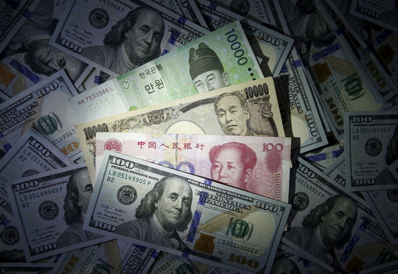 © Reuters. South Korean won, Chinese yuan and Japanese yen notes are seen on U.S. 100 dollar notes in this picture illustration taken in Seoul