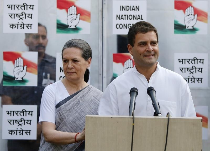 © Reuters. Congress party vice-president Rahul speaks to the media as his mother and chief of Congress Sonia looks on during a news conference in New Delhi