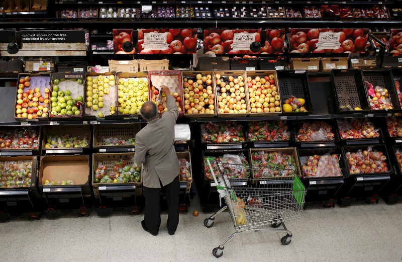 © Reuters. A man chooses apples in an Asda store in northwest London