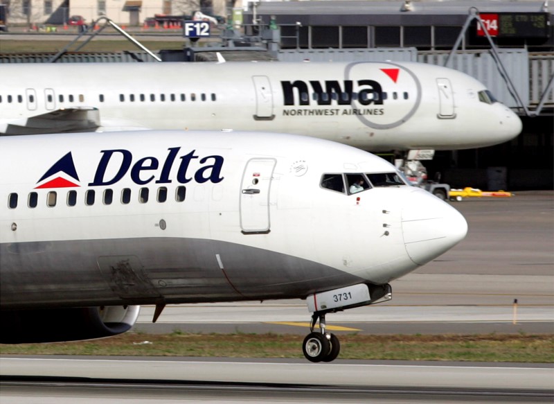 © Reuters. A Delta Air Lines jet takes off past a Northwest Airline jets parked at gates at the Minneapolis St.Paul International Airport