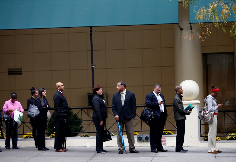 © Reuters. Job seekers stand in line to meet prospective employers at a career fair in New York City