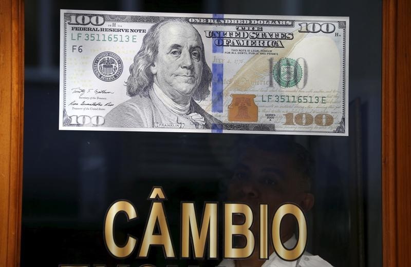 © Reuters. Un poster riproduce la banconota da 100 dollari Usa in un ufficio del cambio a Rio de Janeiro