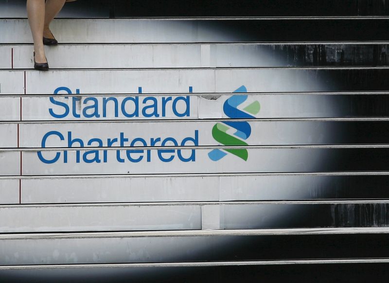 © Reuters. File photo of a woman walking down the stairs of the Standard Chartered headquarters in Hong Kong