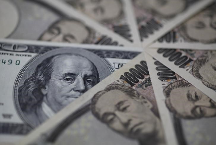 © Reuters. Банкноты доллара США и японской иены 