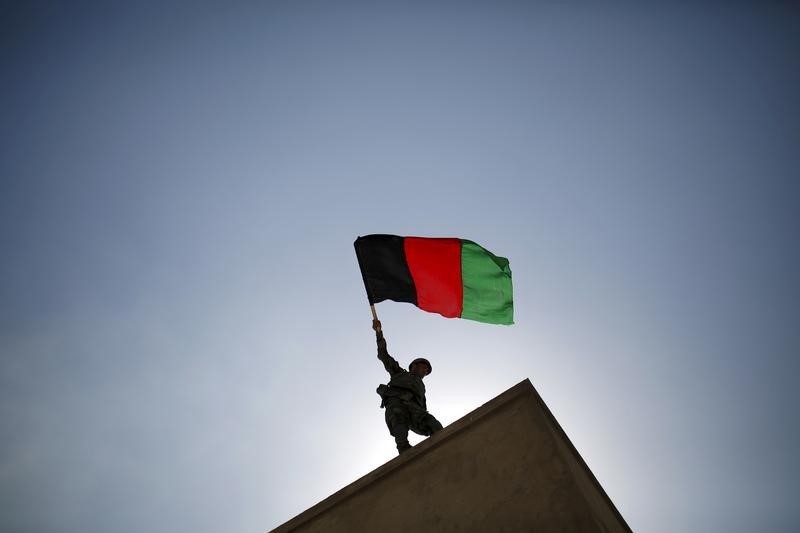 © Reuters. An ANA officer holds an Afghanistan flag during a training exercise at the Kabul Military Training Centre 