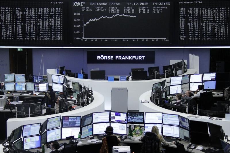 © Reuters. Traders work at desks in front of DAX board at the stock exchange in Frankfurt