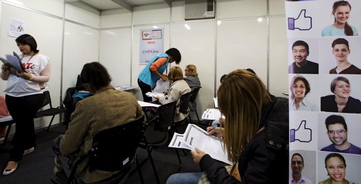 © Reuters. Pessoas preenchendo fichas de emprego em São Paulo