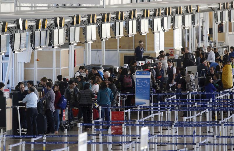 © Reuters. Passengers waits for their flights at the departure area inside the international airport of Santiago