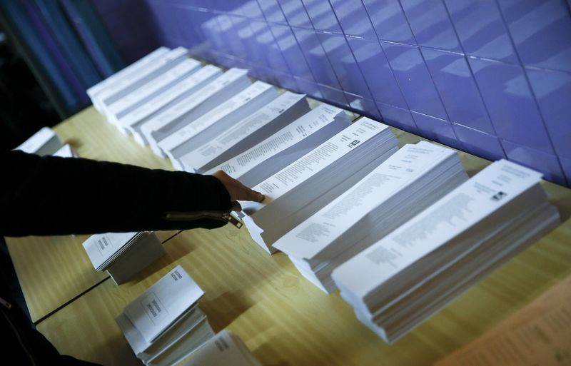 © Reuters. A voter reaches for a ballot before voting in Spain's general election in Hospitalet de Llobregat, near Barcelona