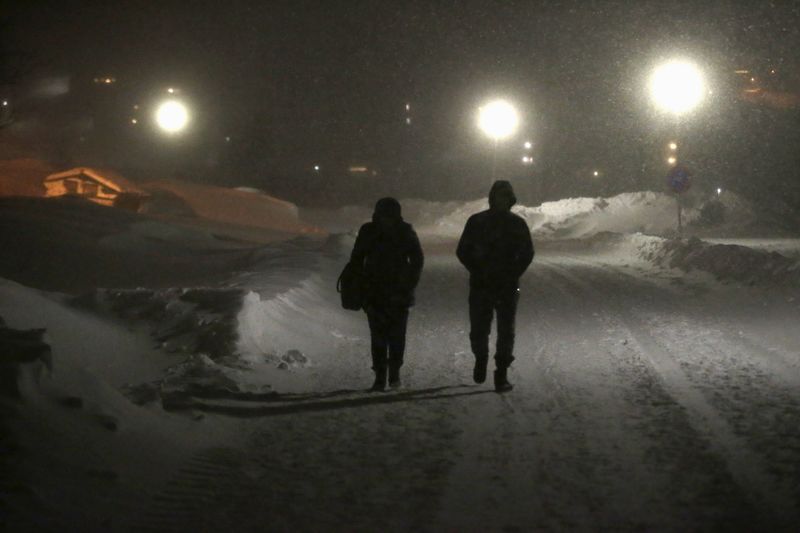 © Reuters. Refugees walk to their camp at a hotel touted as the world's most northerly ski resort in Riksgransen