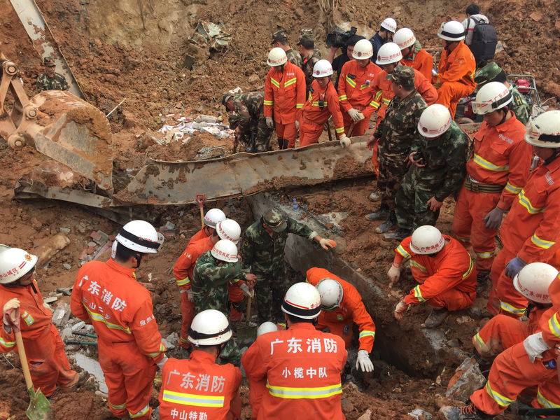 © Reuters. Firefighters search for survivors after buildings collapsed at the site of a landslide at an industrial park in Shenzhen