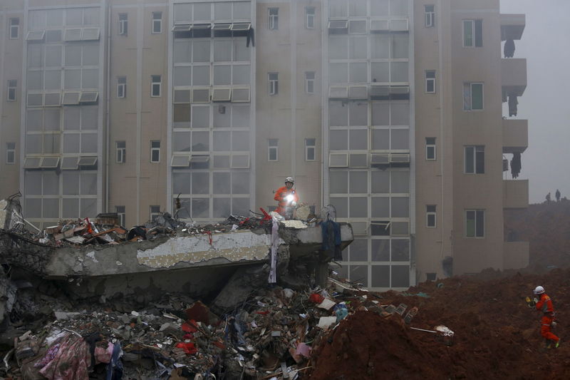 © Reuters. Firefighters search for survivors among the debris of collapsed buildings after a landslide hit an industrial park in Shenzhen