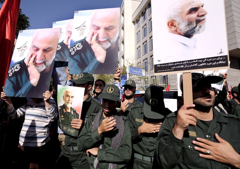 © Reuters. Membros da Guarda Revolucionária segurando fotos do general iraniano Hossein Hamedani durante seu funeral, em Teerã