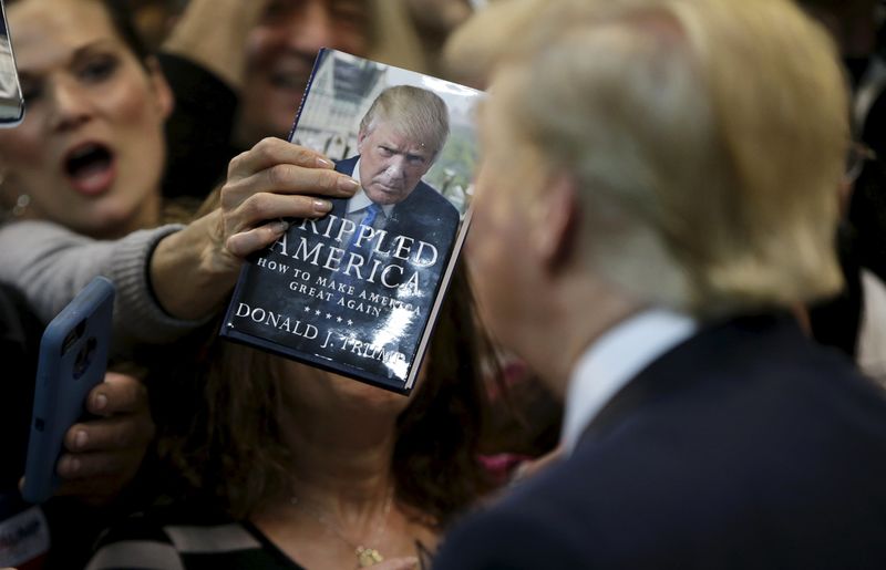 © Reuters. Woman thrusts book at Republican presidential candidate Trump at his campaign rally in Manassas, Virginia