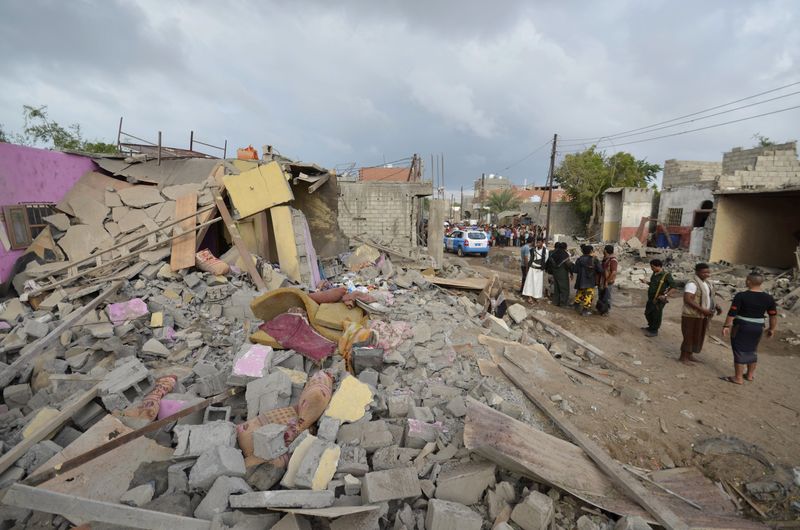 © Reuters. Pessoas se reúnem perto de casas destruídas por ataques da coalizão em Houdieda