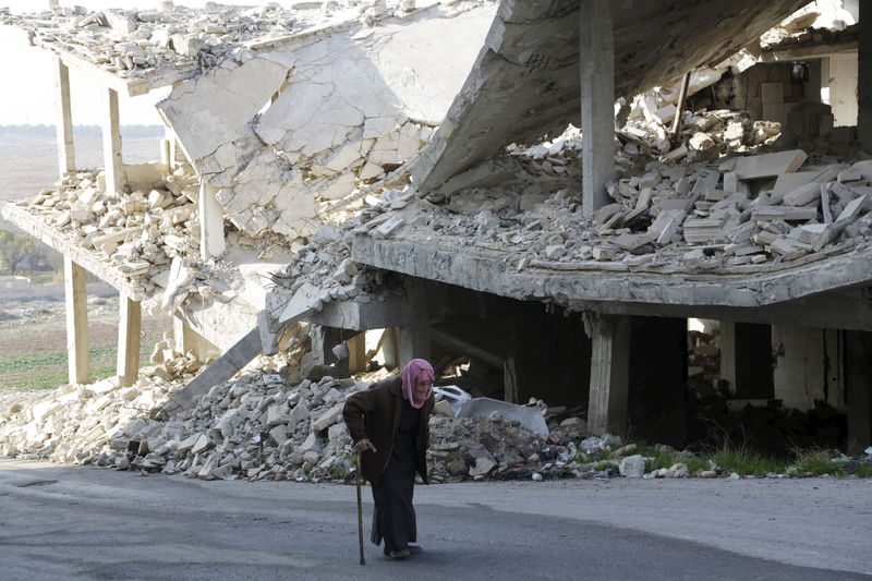 © Reuters. Homem em frente prédios destruídos na província de Idlib, Síria