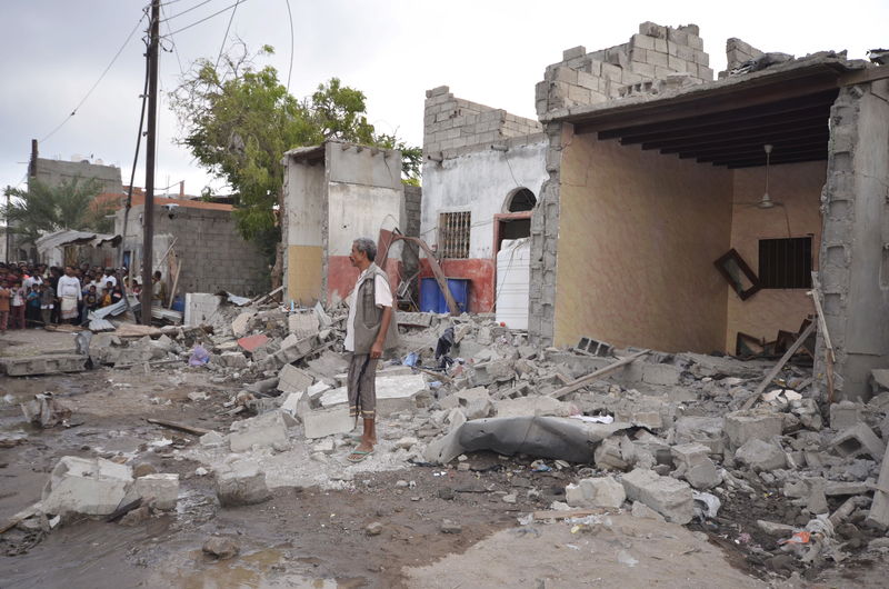 © Reuters. A man stands on the wreckage of a house destroyed by a Saudi-led air strike in Yemen's Red Sea port city of Houdieda