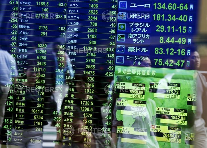 © Reuters. Passersby are reflected on a screen displaying  stock quotation, the stock market indices of various countrie and  exchange rates  at a brokerage in Tokyo