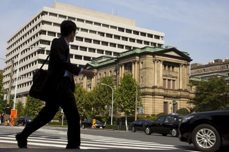 © Reuters. A man walks past BOJ building in Tokyo