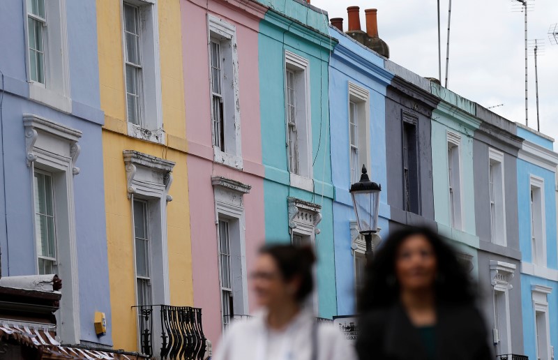 © Reuters. Pedestrians walk past a row of houses in London