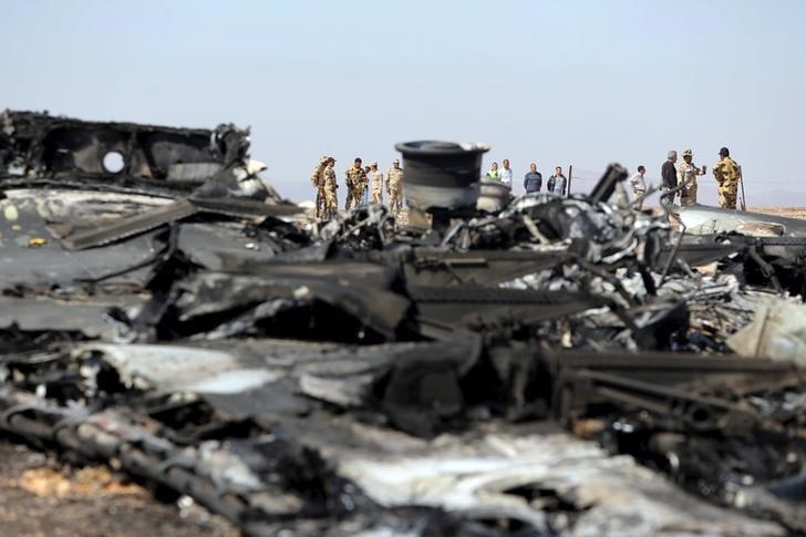 © Reuters. Egyptian military investigators stand near the debris of a Russian airliner at the site of its crash at the Hassana area in Arish city, north Egypt