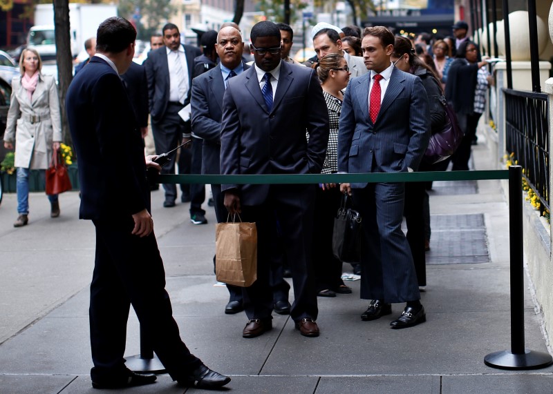 © Reuters. Job seekers stand in line to meet prospective employers at a career fair in New York City