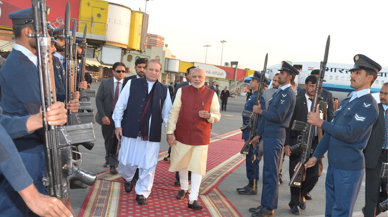 © Reuters. El primer ministro pakistaní Nawaz Sharif (izquierda) camina con su par de India Narendra Modi en Lahore, Pakistán