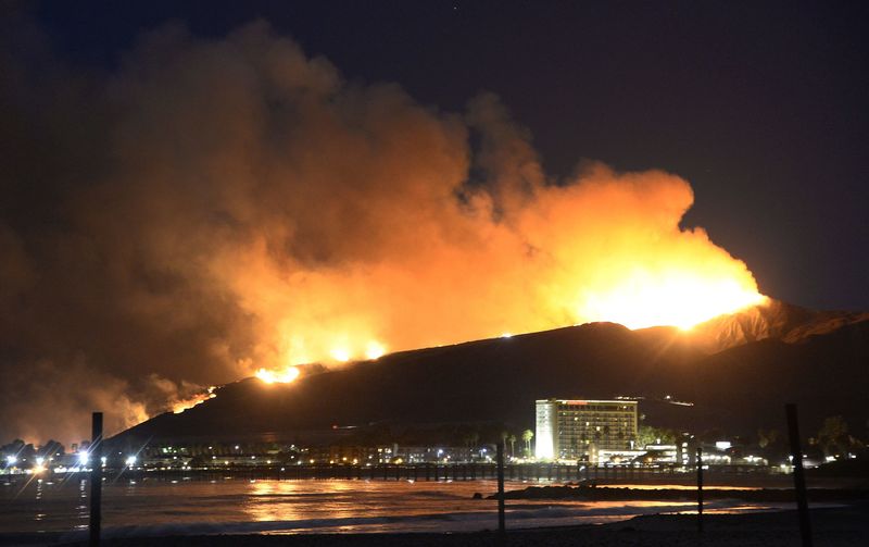 © Reuters. Huge flames light up the coast line the Solimar brush fire that started early Saturday morning in Ventura County