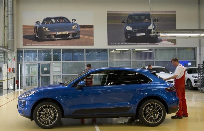 © Reuters. Worker inspects finished Macan car at Porsche at new plant in Leipzig