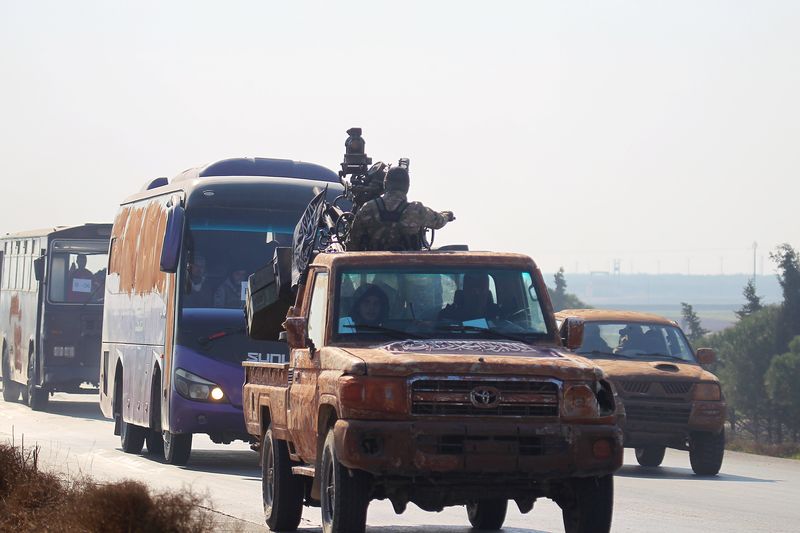 © Reuters. Combatentes de milícias pró-governo sírio e civis vistos na província de Idlib