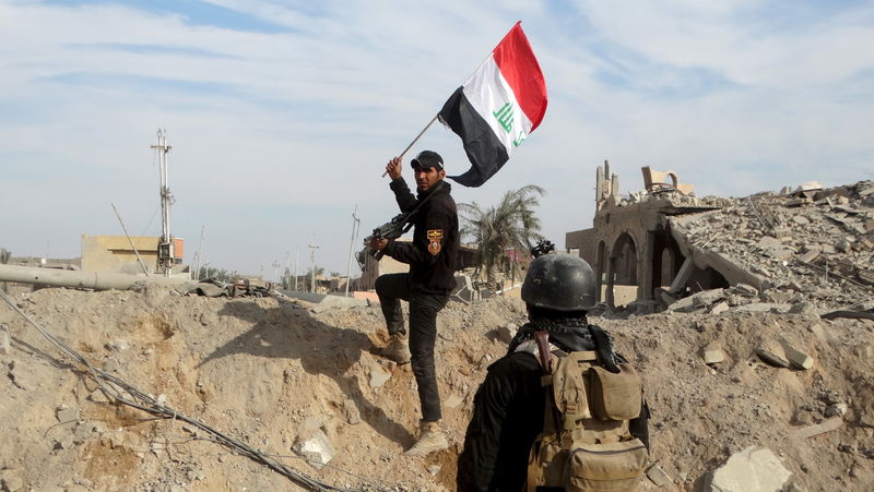 © Reuters. Membro das forças de segurança do Iraque segurando bandeira nacional iraquiana na cidade de Ramadi