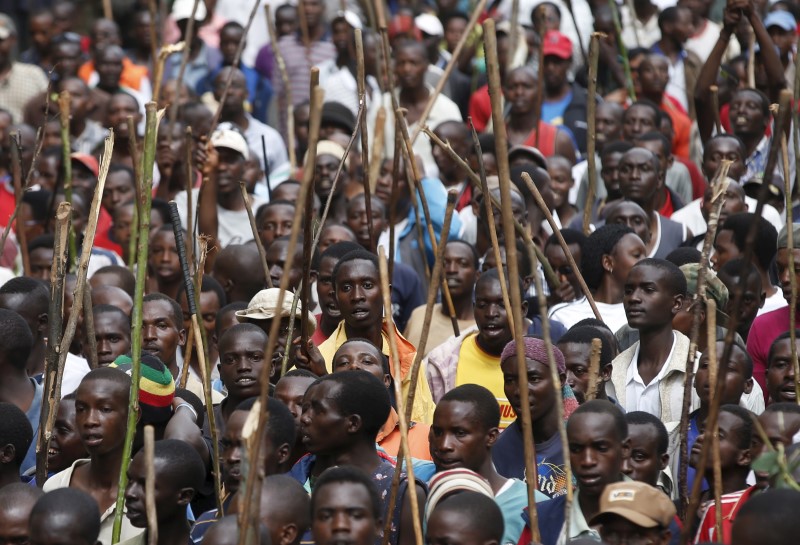 © Reuters. Protesters who are against Burundi President Pierre Nkurunziza and his bid for a third term march towards the town of Ijenda, Burundi