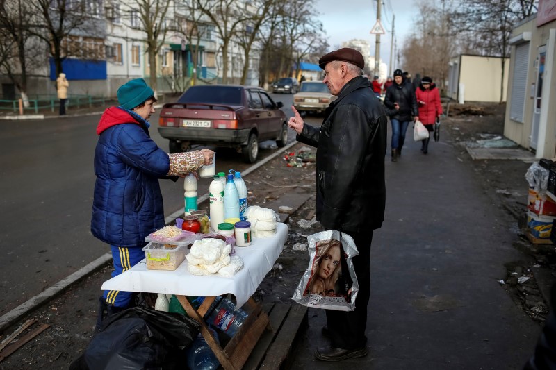 © Reuters. A vendor sells soybean milk on a street at a residential sector affected by shelling in Mariupol, a city on the Sea of Azov, eastern Ukraine