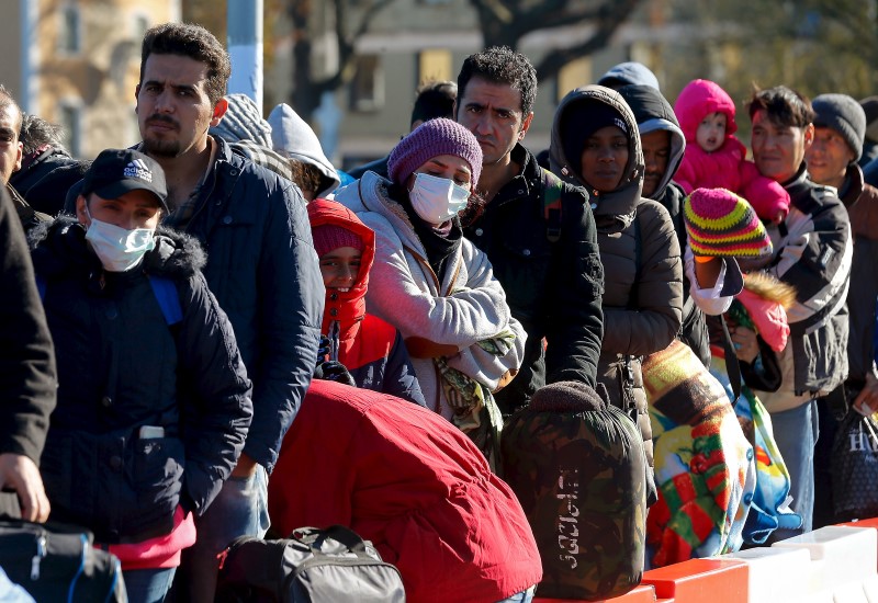 © Reuters. Migrants queue on a bridge crossing the border river Inn at the German-Austrian frontier between Braunau and Simbach am Inn near Passau