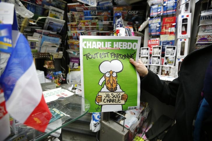 © Reuters. Homem segura edição do jornal satírico francês Charlie Hebdo em frente a quiosque em Paris