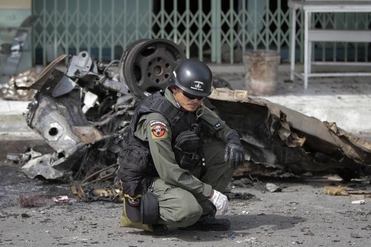 © Reuters. Policial ao lado de destroços de carro em Narathiwat, Tailândia