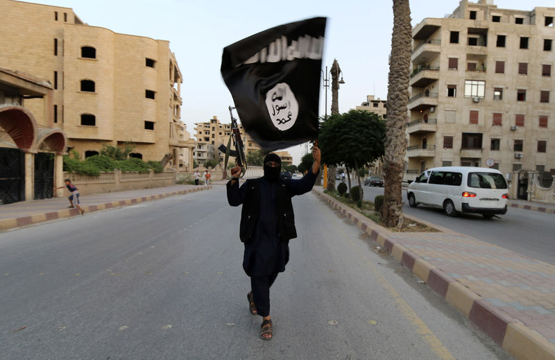 © Reuters. Homem com bandeira do Estado Islâmico em Raqqa, Síria