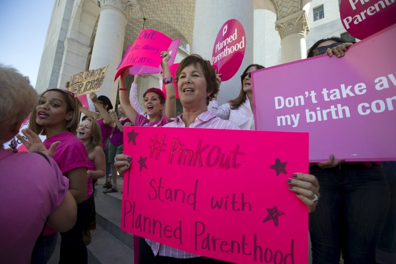 © Reuters. Activists hold signs as they rally in support of Planned Parenthood on "National Pink Out Day" on the steps of City Hall in Los Angeles