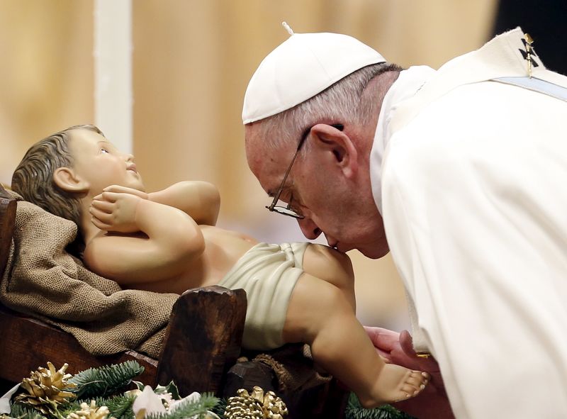 © Reuters. El Papa Francisco besa una imagen del niño Jesús durante una misa de Año Nuevo en la Basílica de San Pedro en el Vaticano