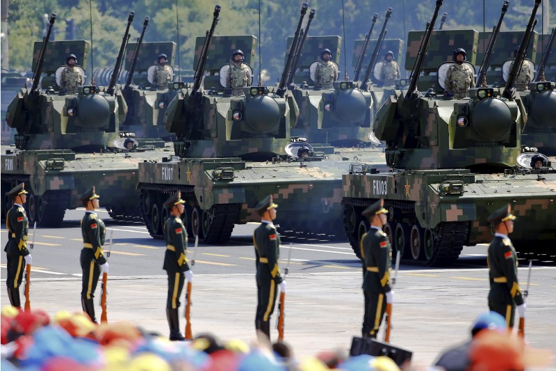 © Reuters. China's People's Liberation Army (PLA) soldiers on their armoured vehicles equipped with anti-aircraft artillery roll to Tiananmen Square during the military parade marking the 70th anniversary of the end of World War Two, in Beijing